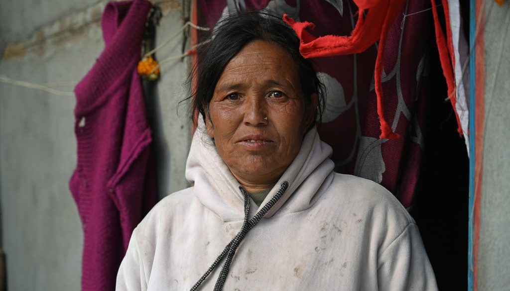 Woman standing in white hoody in front of door opening