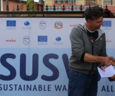 Two men shaking hands outside in front of a SUSWA logo